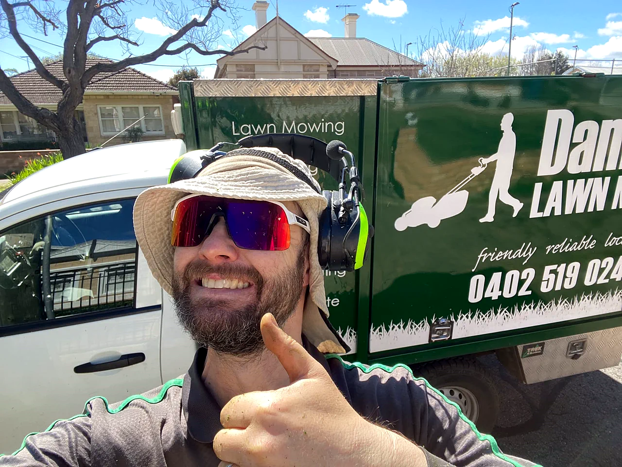 Damien beside his branded Damien's Lawn Mowing ute